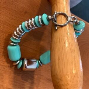 Bracelet with plastic string beads in silver tone and aqua blue toggle clasp